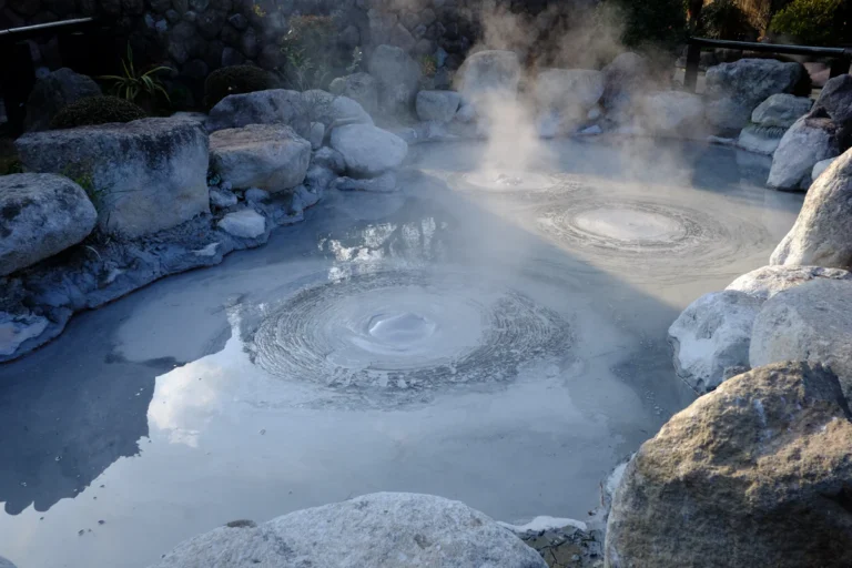 Aguas termales con vapor entre rocas